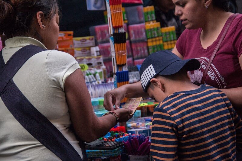 Mujer y niño compran útiles escolares