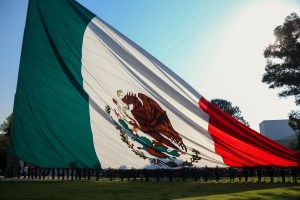 Previo al incio de la ceremonia por el Día de la Bandera, la Escolta del Ejército Mexicano desenfunda la bandera nacional