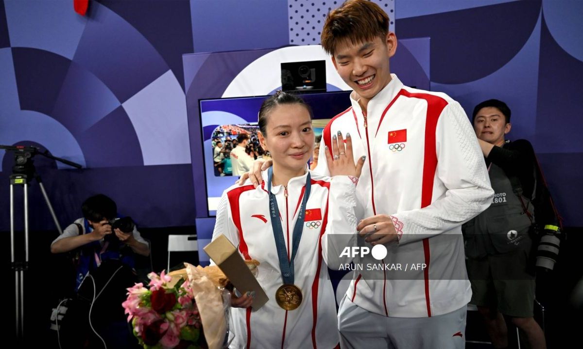 La medallista de oro de China, Huang Ya Qiong, posa con su anillo de compromiso después de aceptar una propuesta de matrimonio de su pareja Liu Yuchen