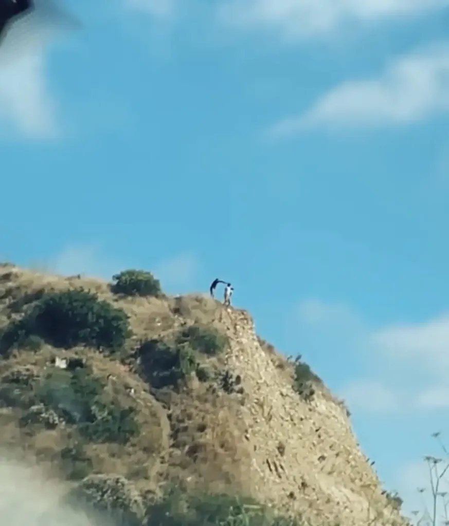 Foto: Captura de pantalla/ Hombres lanzando piedras desde lo alto de la colina