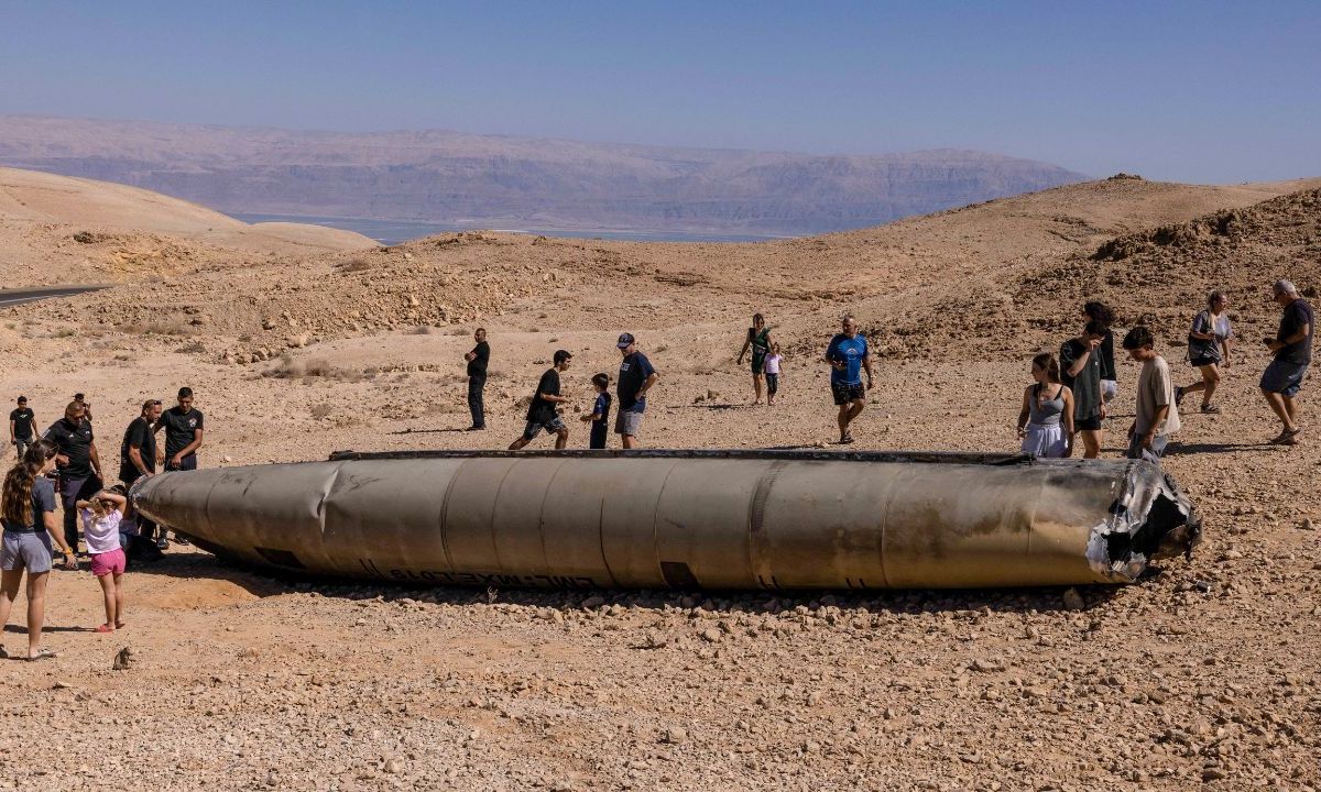 IMPRESIÓN. Personas visitan restos de un misil iraní en el desierto de Negev, en el sur de Israel. 