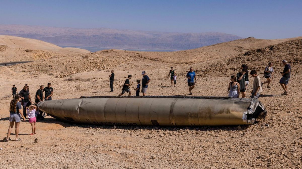 IMPRESIÓN. Personas visitan restos de un misil iraní en el desierto de Negev, en el sur de Israel. 