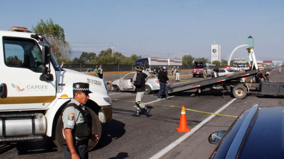 VIOLENCIA. El auto completamente incinerado contenía los cadáveres embolsados; extraoficialmente se dijo que primero fueron asesinados.