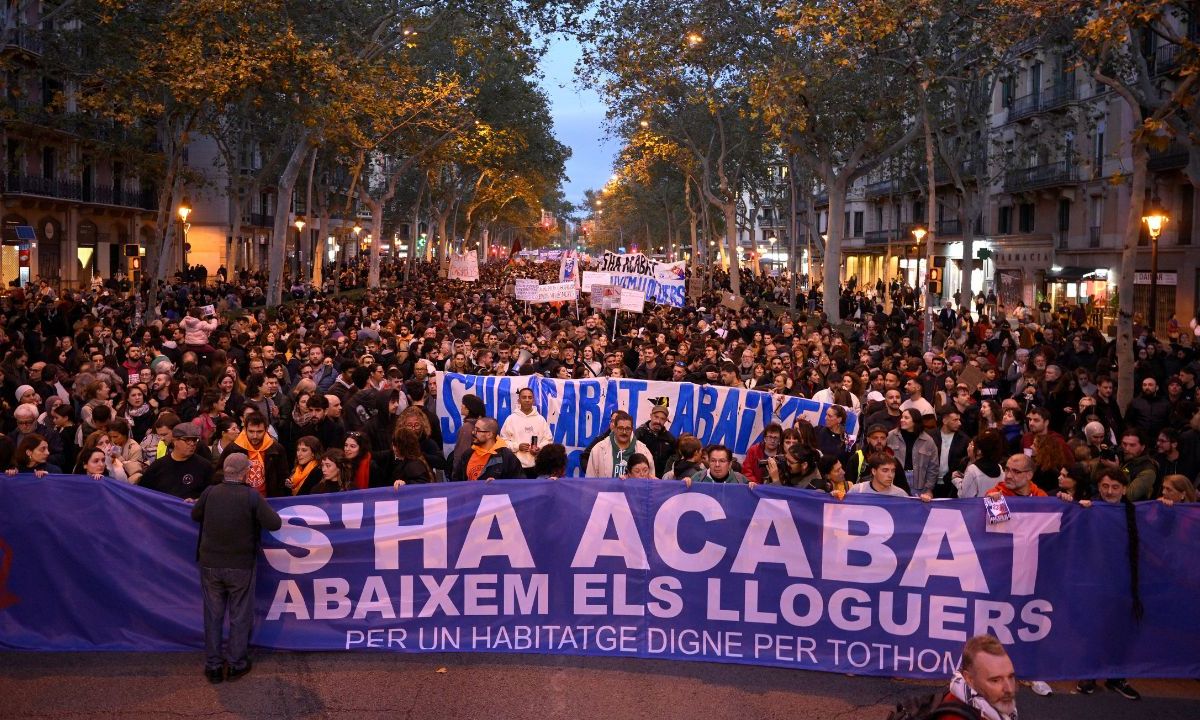 Manifestantes sostienen una pancarta que dice 'Vivienda para todos'