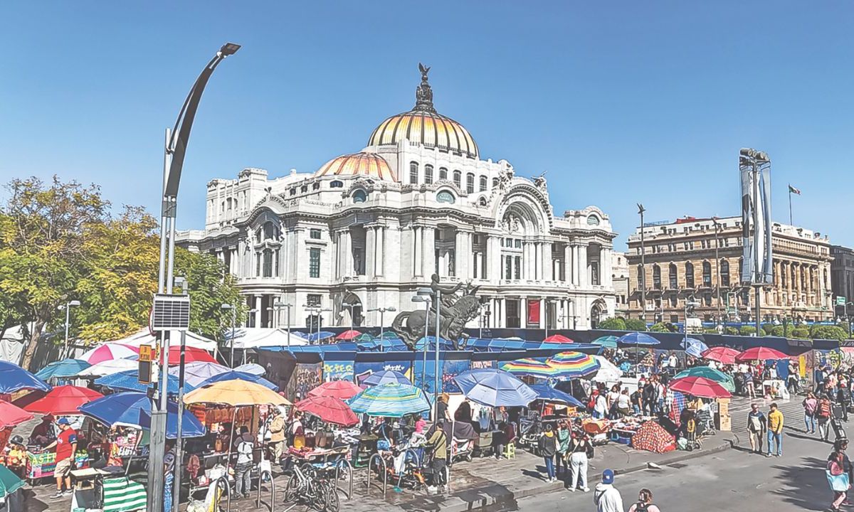 Escenario. Sombrillas de distintos colores y gran variedad de puestos sobresalen de entre las estructuras de metal; algunos capitalinos caminan por debajo de la acera debido al poco espacio para transitar.