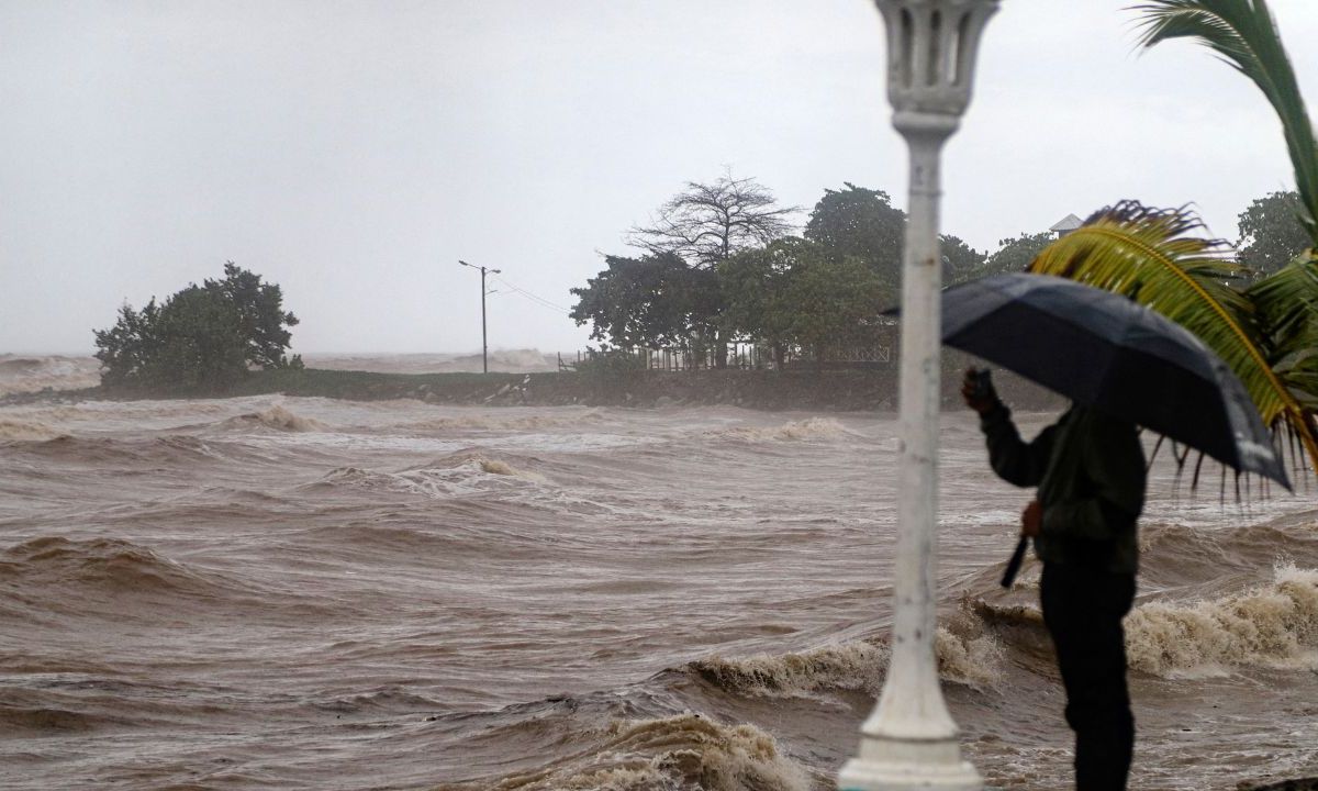 Una persona toma fotografías en el malecón durante el paso de la tormenta tropical Sara en La Ceiba, Honduras.