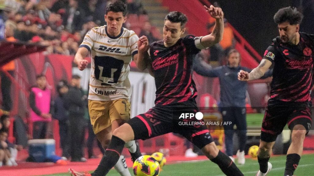 Jugadores de Xolos y Pumas pelean un balón durante el partido de la Jornada 9.