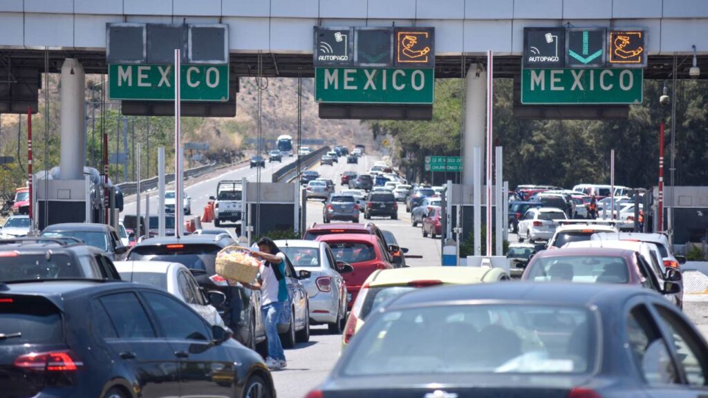 Filas largas de automóviles están a la espera de pasar la caseta de cobro.