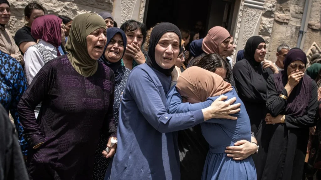 Los dolientes reaccionan durante el funeral de las víctimas de un ataque con misiles iraníes que destruyó un edificio de tres plantas en la ciudad de Tamra, en el norte de Israel