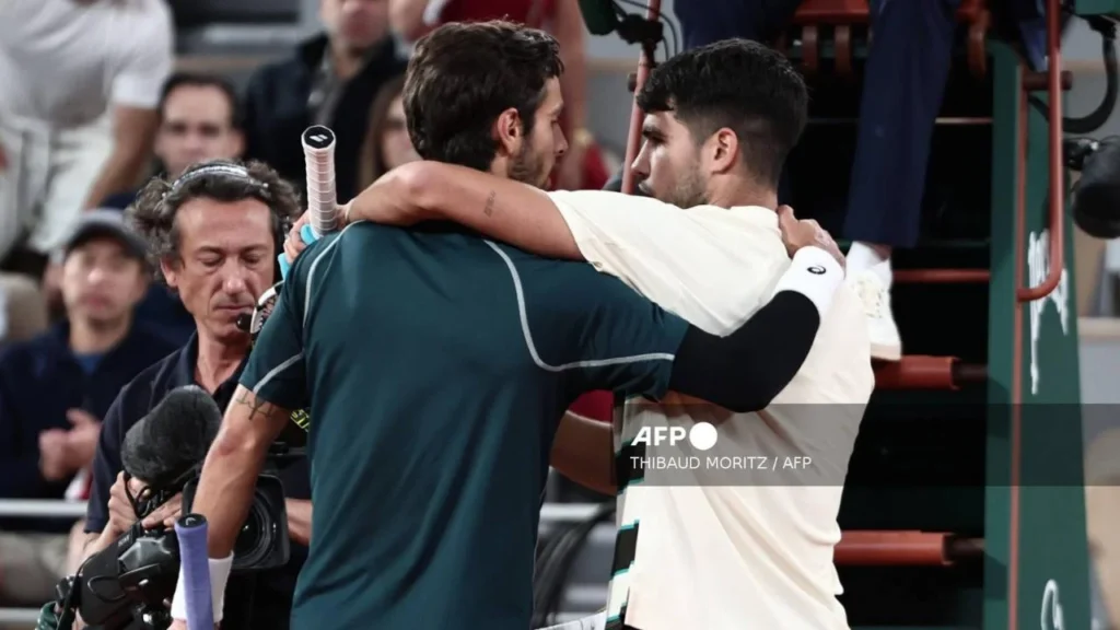 Alcaraz y Musetti se abrazan tras la finalización del partido, luego de que el italiano sufriera una lesión que le impidió continuar el juego.