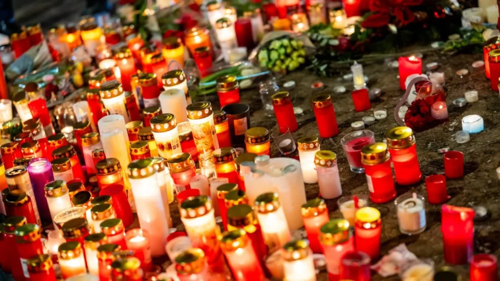 Se exhiben velas en un monumento improvisado cerca del lugar donde se incendió un bar durante las celebraciones de Nochevieja en la estación de esquí alpina de Crans-Montana, el 2 de enero de 2026. El incendio causó la muerte de unas 40 personas y dejó más de 100 heridas.