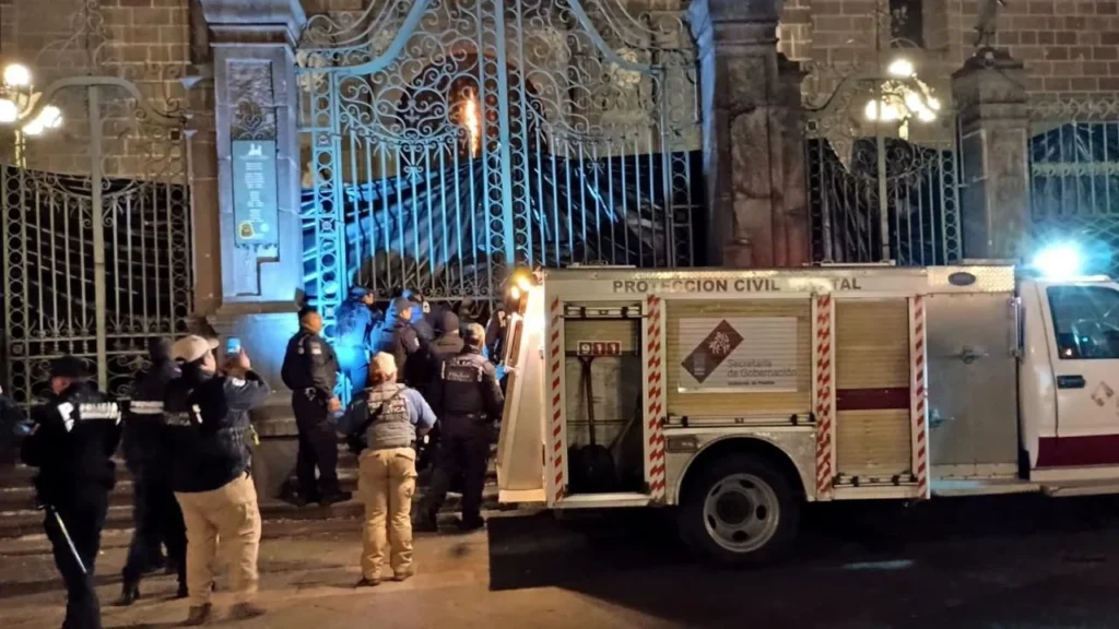 Elementos de emergencia atendieron un incendio en el portón norte de la Catedral de Puebla durante las primeras horas de este sábado.