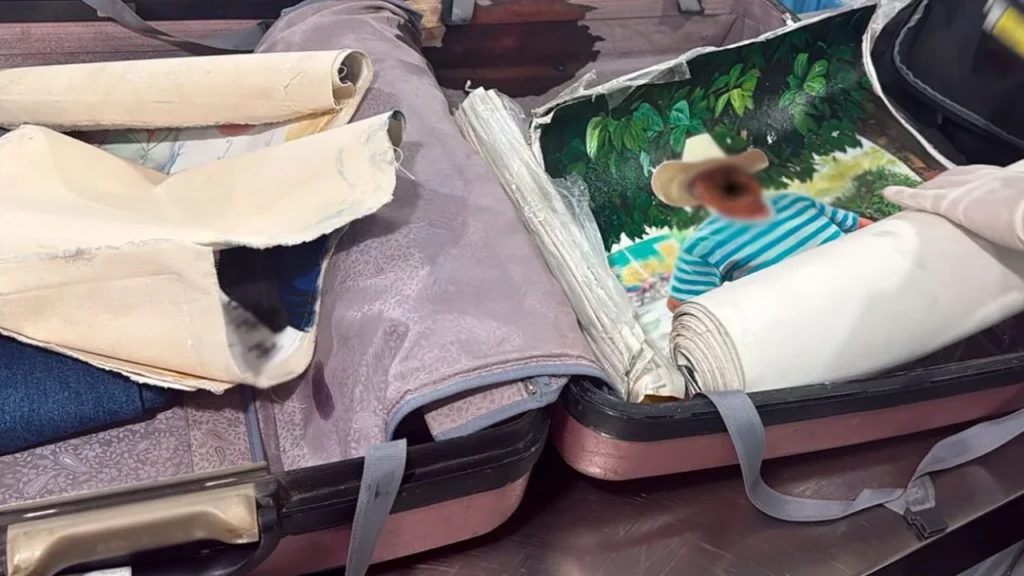 Elementos de la Secretaría de Marina (SEMAR) y del Instituto Nacional de Migración (INM) durante labores de inspección en el AICM, donde fue detenido un extranjero que transportaba cocaína oculta en lienzos pintados.
