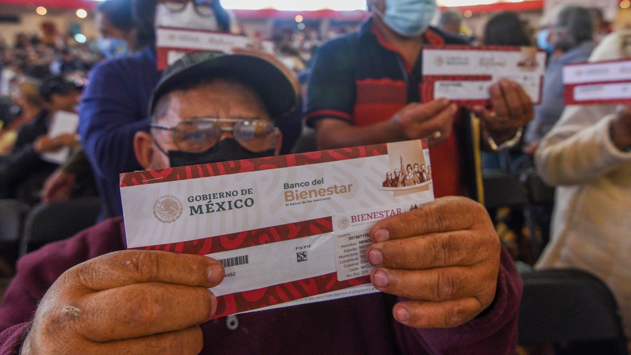 Hombre mayor con su sobre de la tarjeta de su pensión bienestar