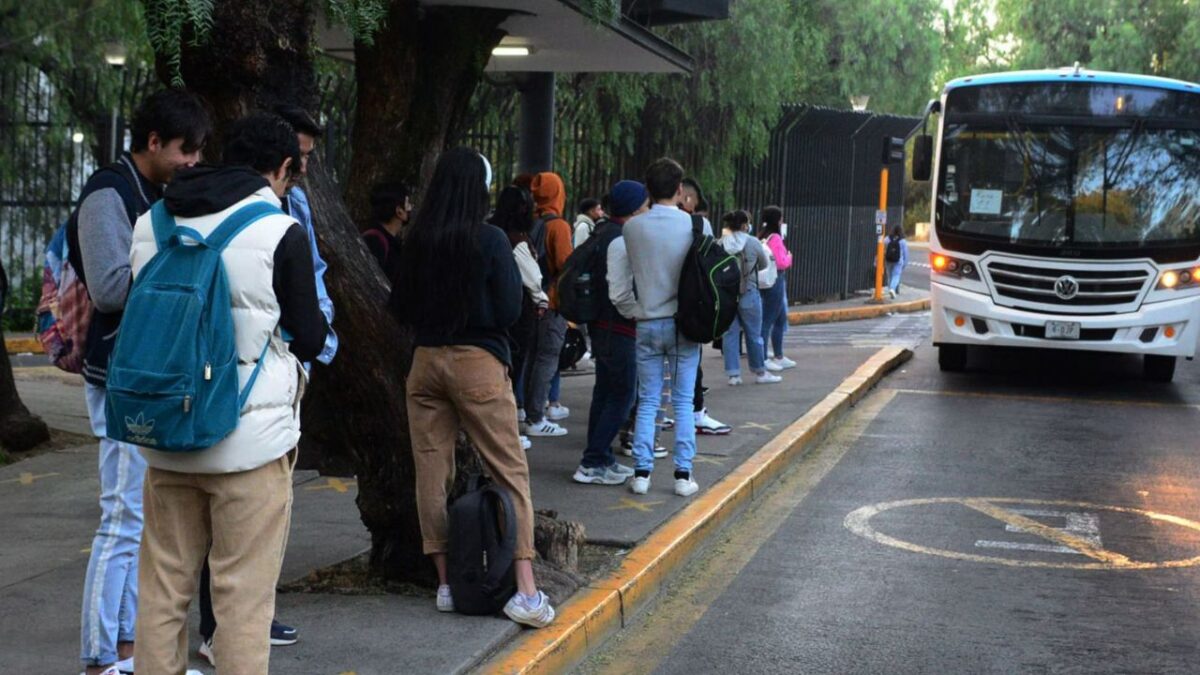 Alumnos esperan en la parada del bus en la capital