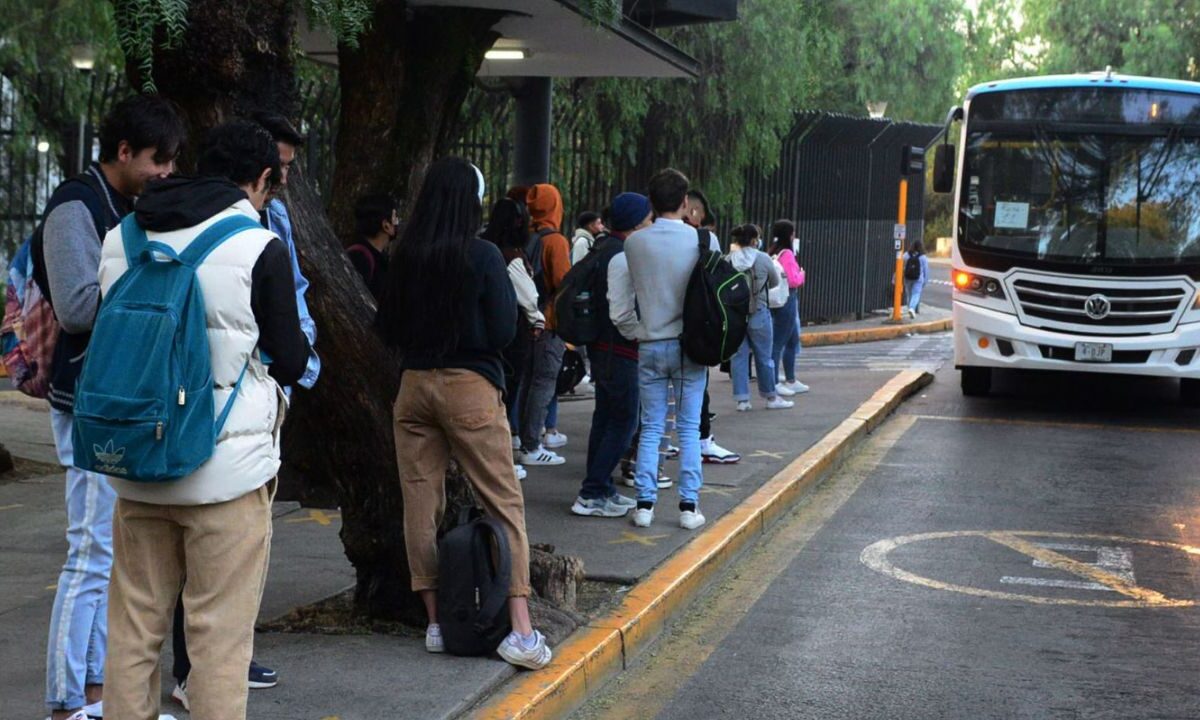 Alumnos esperan en la parada del bus en la capital