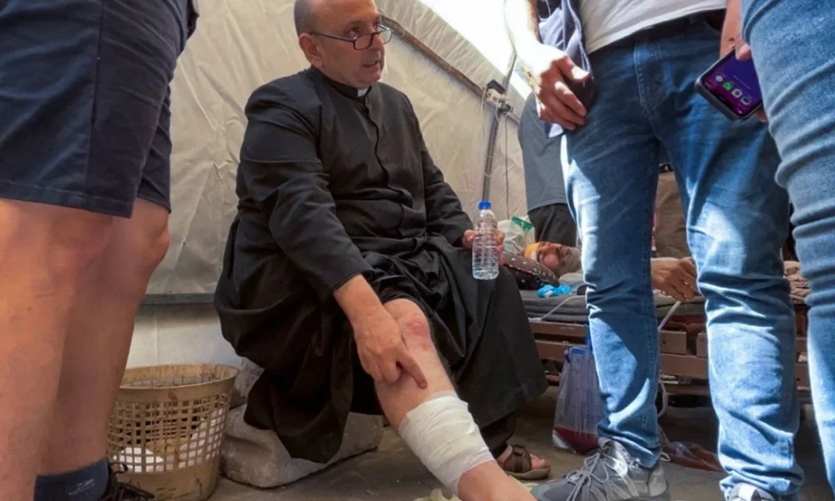 El párroco de la iglesia de la Sagrada Familia en la ciudad de Gaza, el padre Gabriel Romanelli, recibe atención médica tras resultar herido en un ataque israelí contra la iglesia