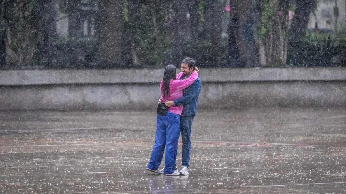 Una pareja se besa bajo la lluvia de la Ciudad de México