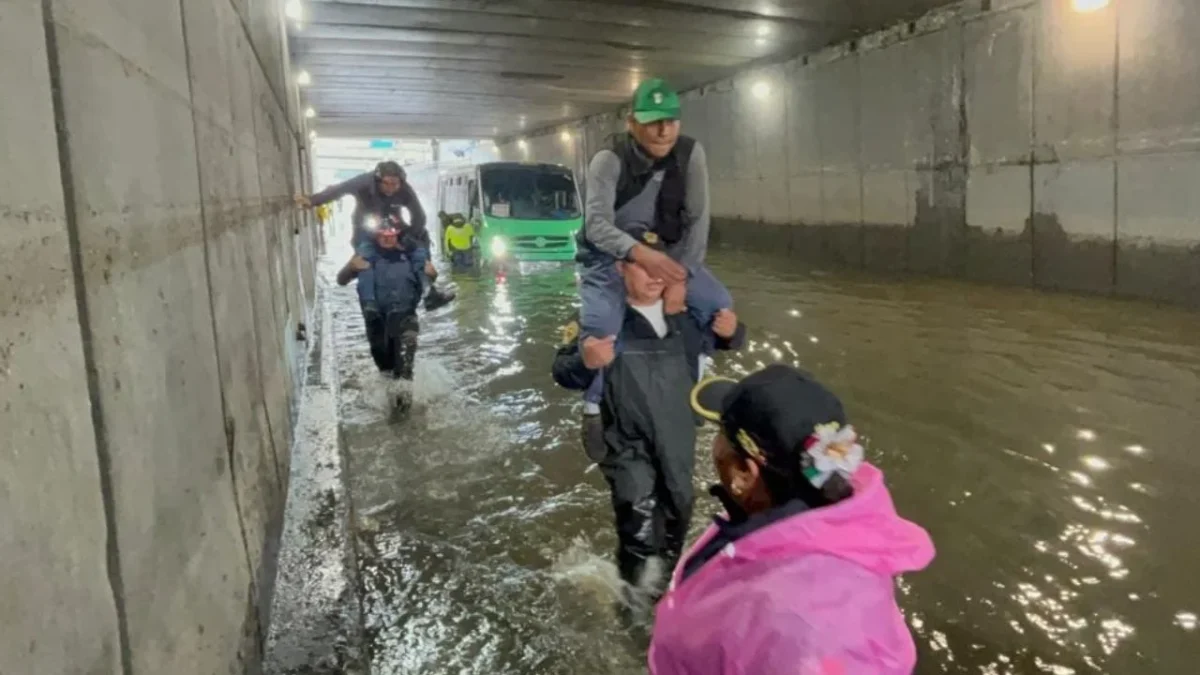 Ayuda. Policías capitalinos cargaron a 63 pasajeros de un autobús que se quedó varado en Iztacalco tras las inundaciones generadas por las fuertes lluvias