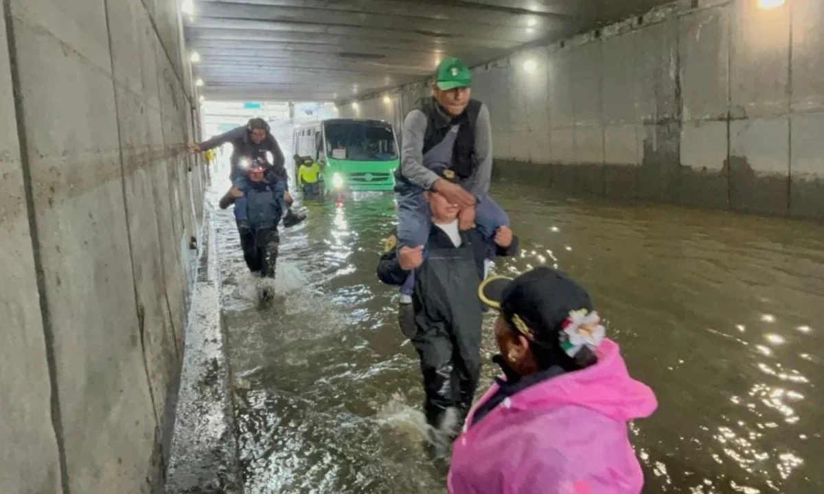 Ayuda. Policías capitalinos cargaron a 63 pasajeros de un autobús que se quedó varado en Iztacalco tras las inundaciones generadas por las fuertes lluvias