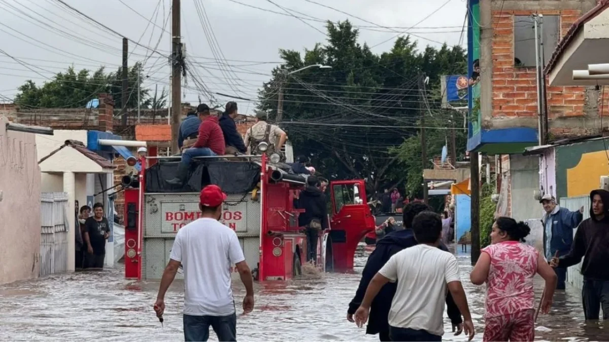 Habitantes de Tototlán caminan entre las aguas que dejaron las precipitaciones.