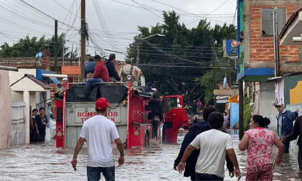 Habitantes de Tototlán caminan entre las aguas que dejaron las precipitaciones.