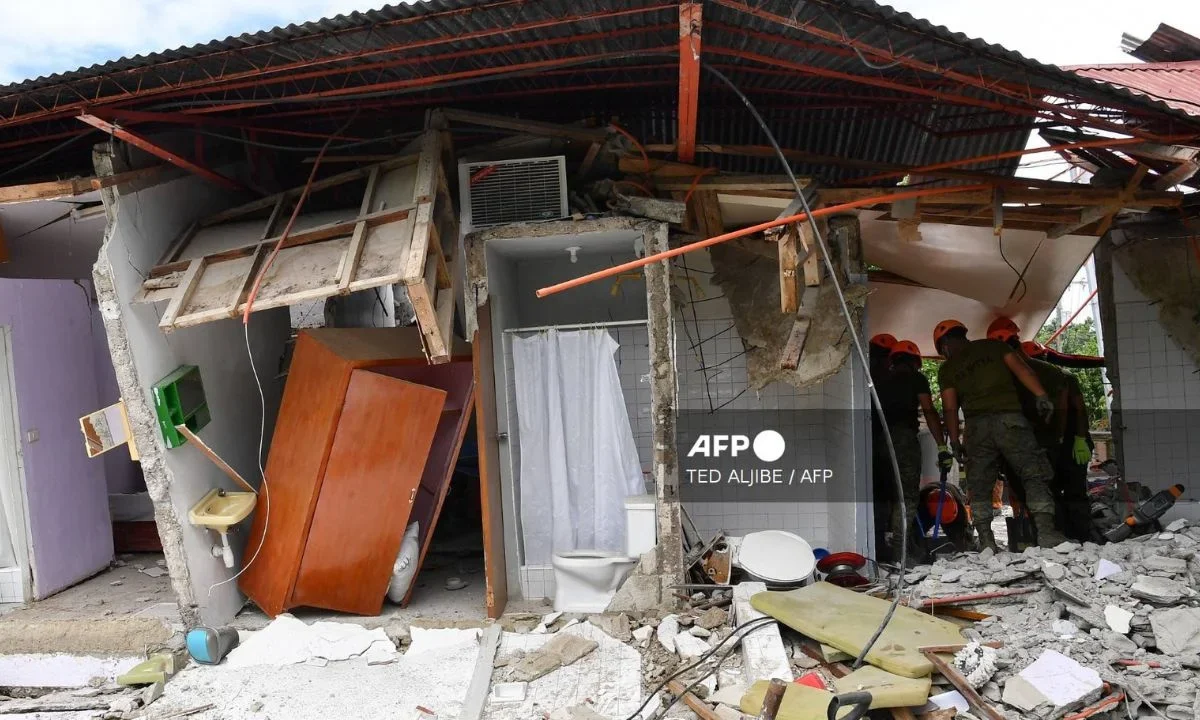 Rescatistas buscan en el lugar donde se derrumbó un edificio y se reportó la desaparición de tres personas tras el terremoto en Filipinas