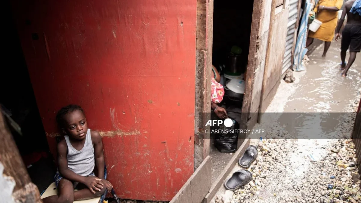 A child looks out at a flooded camp for displaced people following Hurricane Melissa in Port-au-Prince on October 29, 2025.