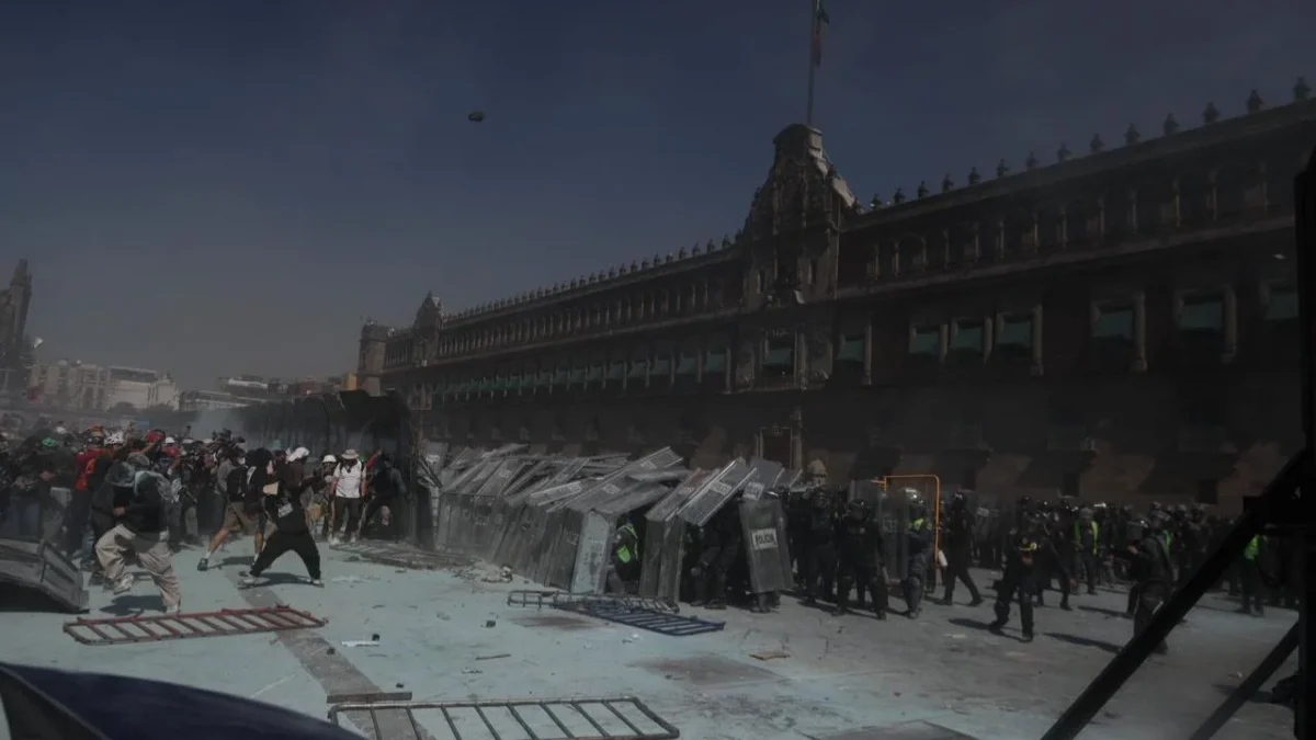 Ante la mayoría de vallas derribadas, la policía forma un muro de escudos y avanza para alejar a los manifestantes de Palacio.