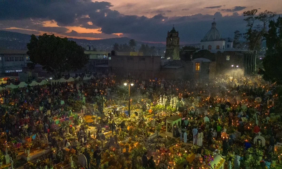 El panteón de San Andrés Mixquic reúne a miles de asistentes que buscan ser parte de la tradicional alumbrada por el Día de Muertos.
