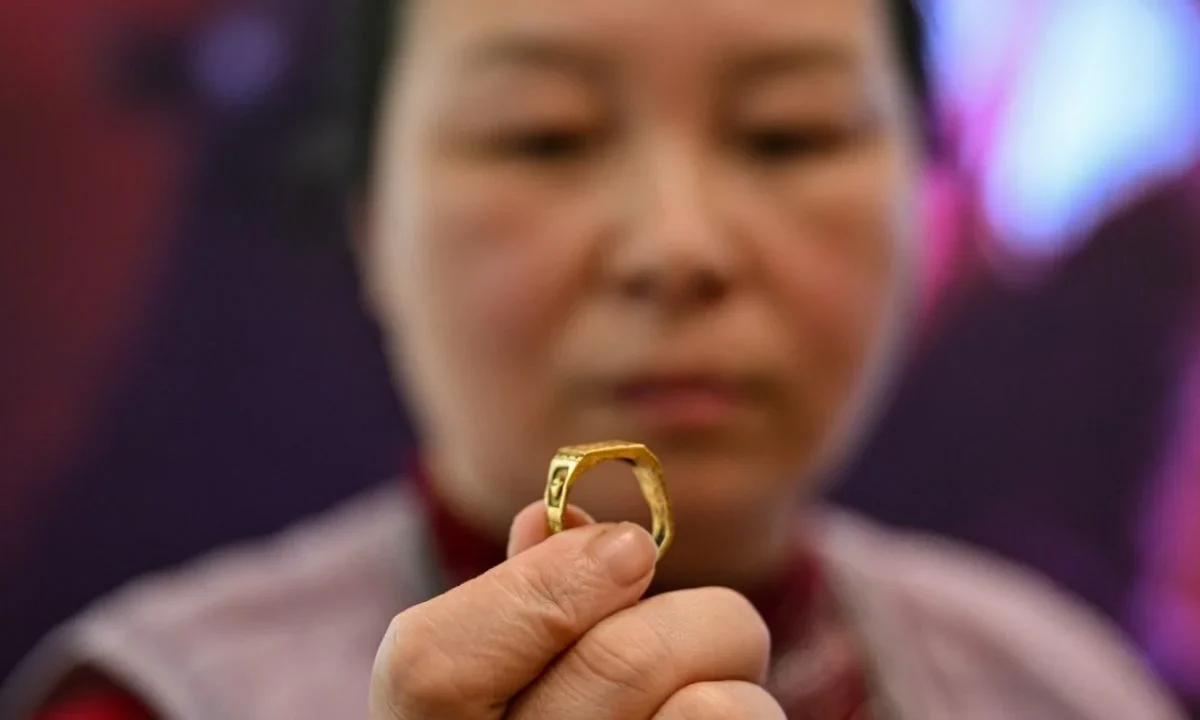 En China, decenas de personas se aglomeran en torno a una máquina para reciclar oro, cuyo precio está batiendo récords.