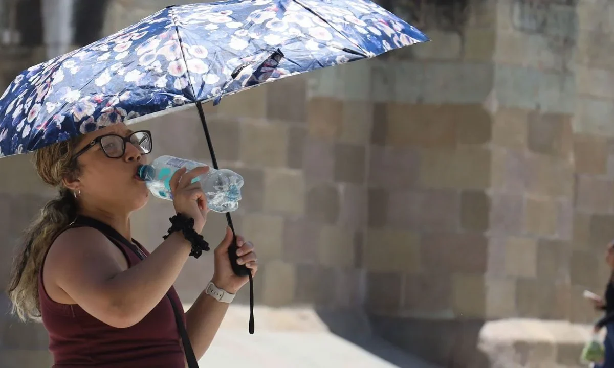 Personas se protegen del sol ante las altas temperaturas registradas en el país durante el clima hoy.