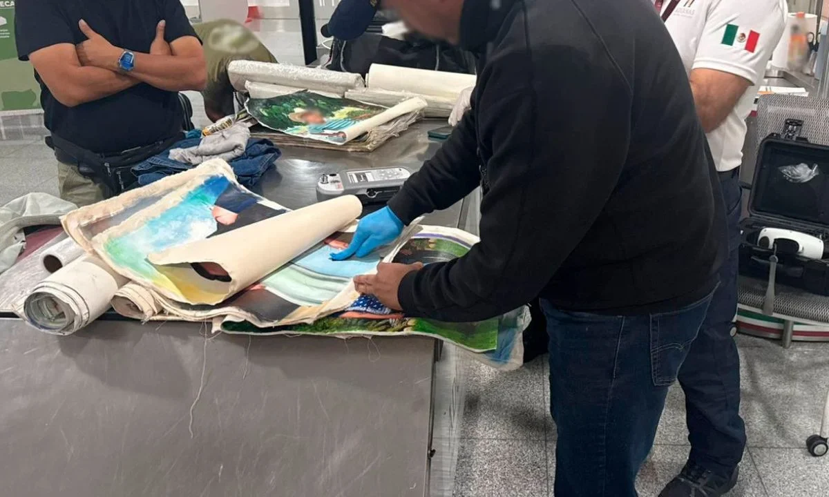 Elementos de la Secretaría de Marina (SEMAR) y del Instituto Nacional de Migración (INM) durante labores de inspección en el AICM, donde fue detenido un extranjero que transportaba cocaína oculta en lienzos pintados.