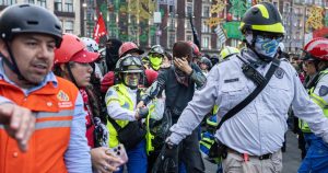 Personal del gobierno asistiendo a joven herido en la marcha de 2 de octubre
