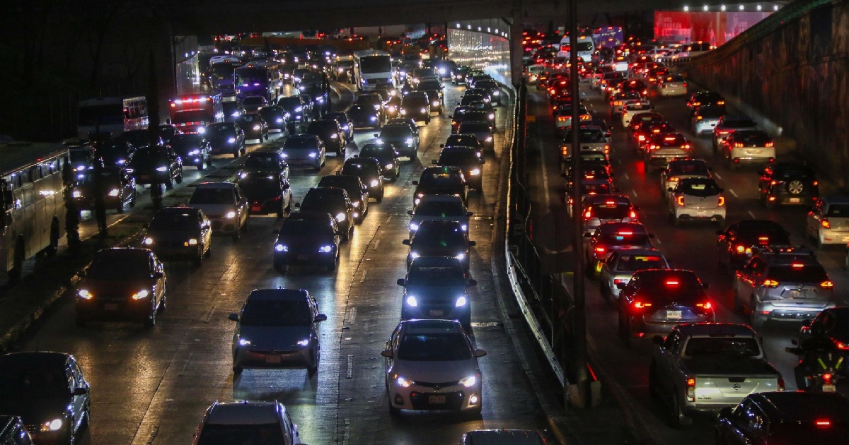 cientos de automóviles parados en una avenida de noche 
