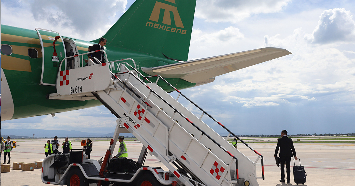 pasajeros descendiendo de avión de mexicana 