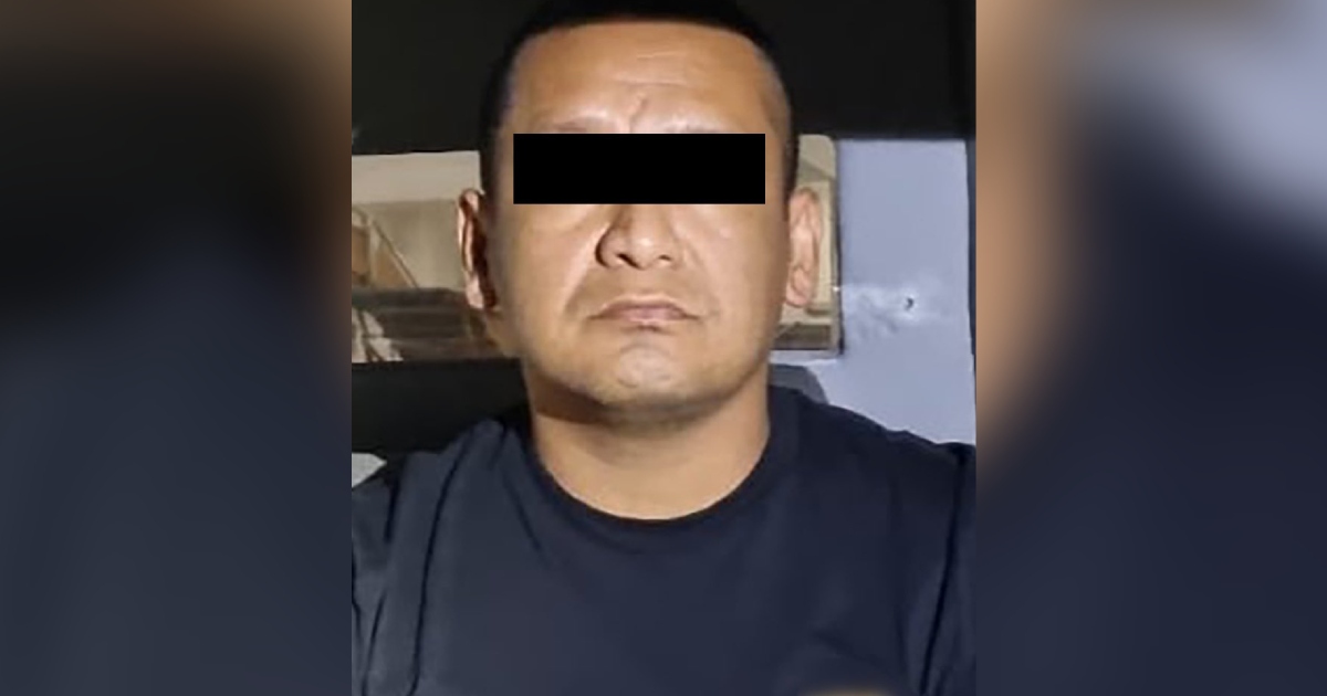 Retrato tipo ficha policiaca (mugshot) en primer plano de Iván «N», alias «El Tanque», presunto operador criminal capturado en Zapopan, Jalisco. El sujeto viste una playera azul oscura o negra y aparece con la mirada fija al frente, con los ojos cubiertos y censurados por una franja rectangular negra en cumplimiento de los protocolos de presunción de inocencia.