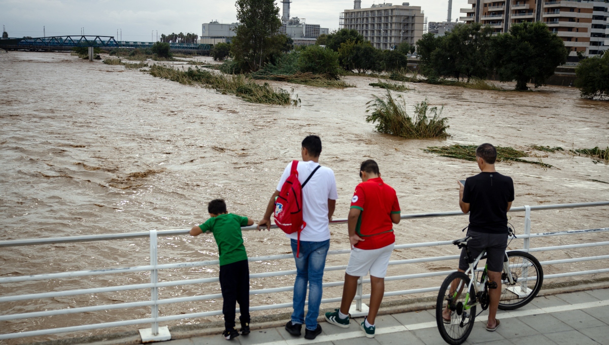 Personas observan el caudaloso río Besòs tras las lluvias torrenciales en Sant Adrià de Besòs, en las afueras de Barcelona | Foto: AFP