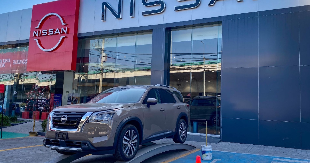 Concensionario de nissan con un auto al exterior 